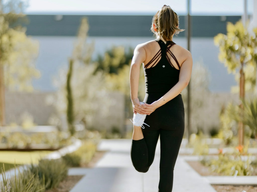 Women Stretching Outdoors Lastics Quad Stretch